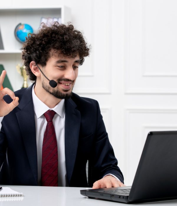 customer-service-handsome-young-guy-office-suit-with-laptop-headset-showing-ok-gesture (1)